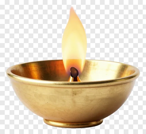 A brass diya with a single flame burning.