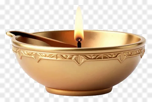 A lit golden metal diya lamp.