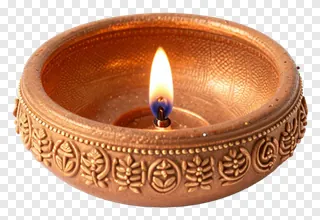 A copper diya with decorative patterns and a lit flame.