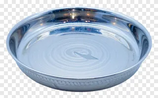 A polished metal Diwali pooja thali with decorative grooves.