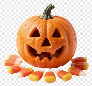 A carved pumpkin with candy corn scattered around it.