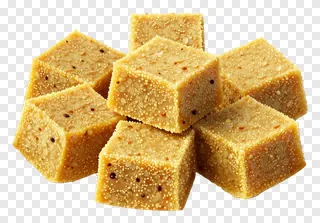 A pile of besan ladoo cubes topped with sesame seeds.