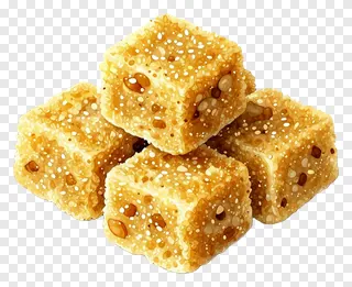 Stack of golden besan ladoo cubes with visible seeds.