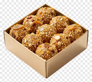 A box of golden Indian sweets with decorative toppings.