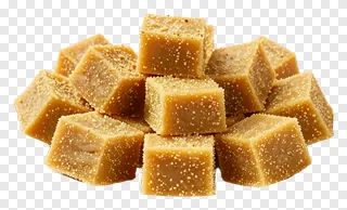 Stack of besan ladoo cubes with sesame seeds.