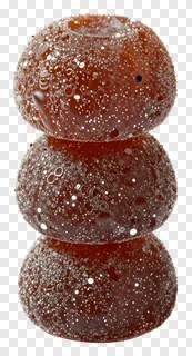 Three stacked til ladoo sweets with glittery sugar coating.